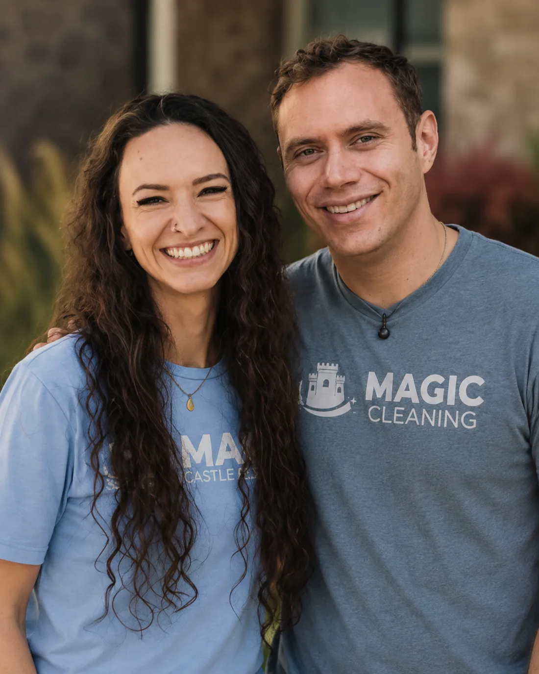 The Magic Castle Cleaning owners smiling outside in matching Magic Cleaning t-shirts